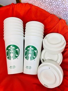 starbucks cups and plates sitting on a red blanket