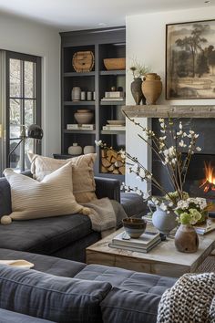 a living room filled with furniture and a fire place in front of a window covered in bookshelves