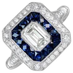 This captivating geometric engagement ring showcases a brilliant GIA-certified emerald cut diamond weighing 0.51 carats, with a G color and VS2 clarity. The center diamond is encircled by a double halo of round brilliant-cut diamonds and French-cut blue sapphires. Crafted in platinum, this ring boasts a sleek, low-profile design. Ring Size: 6.5 US, Resizable Certification: GIA Certificate Color: G Color Clarity: VS2 Metal: Platinum Stone: Diamond, Sapphire Stone Cut: Emerald Cut Style: Art Deco Geometric Engagement Ring, Emerald Cut Diamond Engagement Ring, Emerald Cut Diamond Engagement, Emerald Cut Diamond, Double Halo, Sapphire Stone, Emerald Cut Diamonds, Stone Cuts, Jewelry Rings Engagement