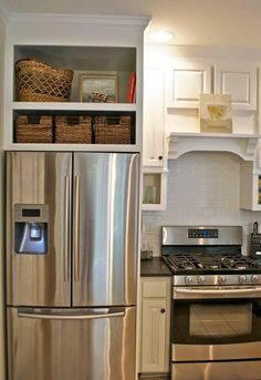 a silver refrigerator freezer sitting inside of a kitchen next to a stove top oven