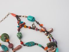 "Listing is for a vintage handmade southwestern mixed gemstones multi strand beads necklace with sterling silver adjustable chain and charms. Beautiful, mixed gemstones Native American style HEISHI necklace with large turquoise center piece. Necklace measures 16\" with 3\" of adjustable chain. Drops down to 4.5\". Stones are turquoise, corals, mother of pearls, agate, carnelian, jasper. There are two small charms of the Indian Chief in Feather Headdress and Kokopelli. Necklace is strung on nylon Adjustable Multi-strand Bohemian Turquoise Necklace, Bohemian Multi-strand Adjustable Turquoise Necklace, Adjustable Bohemian Multi-strand Turquoise Necklace, Vintage Multi-strand Turquoise Jewelry, Bohemian Multi-stone Round Bead Necklace, Bohemian Multi-stone Necklace, Southwestern Multi-strand Turquoise Necklace For Jewelry Making, Handmade Multicolor Multi-strand Turquoise Necklace, Vintage Multicolor Turquoise Necklace With Natural Stones