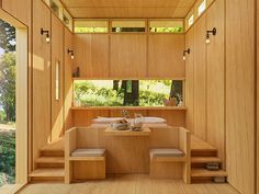 the inside of a house with wooden walls and stairs leading up to an outside dining area