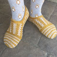 the legs and feet of a person wearing knitted slippers with sheep on them