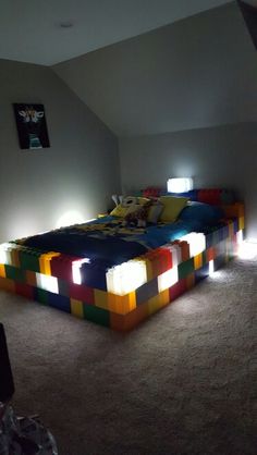 a bed made out of blocks in a room with two lights on the side of it