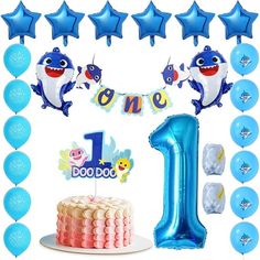 a 1st birthday party with blue balloons and decorations including a shark cake topper, one balloon