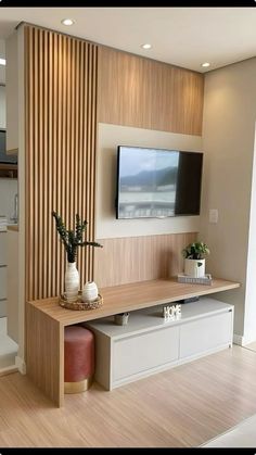 a tv mounted on the wall in a living room with wooden paneling and white furniture