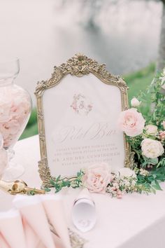 a table topped with pink and white flowers next to a sign that reads, wedding day