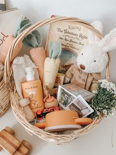 a basket filled with lots of items sitting on top of a white table next to a book