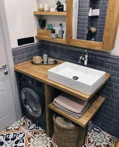 a washer and dryer in a bathroom with tile flooring on the walls