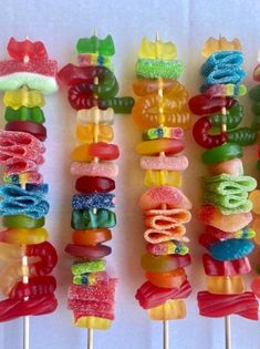 there are many colorful candy lollipops on the skewers with different toppings