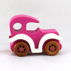 a pink and white toy car sitting on top of a table