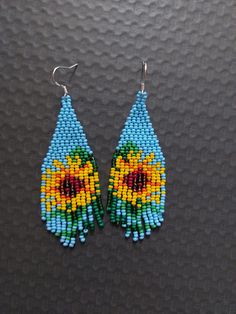 a pair of earrings made out of seed beads