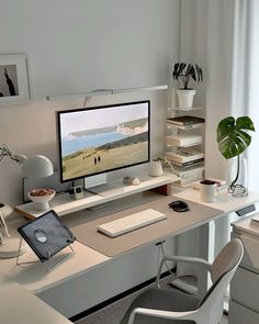 a computer monitor sitting on top of a desk next to a keyboard and mouse in front of a window