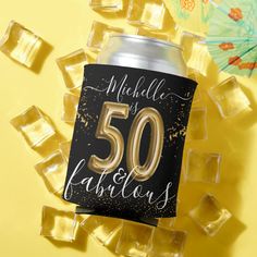 a black and gold 50th birthday can with the number 50 on it surrounded by ice cubes