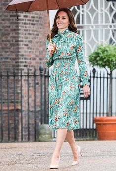 a woman in a green dress holding an umbrella