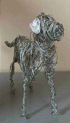 a wire dog sculpture sitting on top of a table