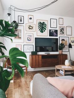 a living room filled with furniture and lots of pictures on the wall above it is a flat screen tv