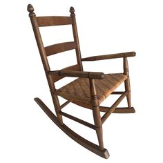 a wooden rocking chair with wicker seat and armrests on an isolated white background