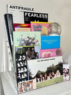 an assortment of records, cds and magazines are on display in a glass holder with acrylic stickers