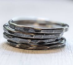 These 925 sterling silver beauties are simple little bands, they're great alone or added to a bohemian stack of rings. If you need multiple sizes with 2 or more rings, just leave the other sized in the message space at checkout. These are hand forged from 14 gauge round sterling silver wire, hammered and oxidized for a greyish black finish, as shown. 14 gauge wire is 1.63 mm before hammering. The silver for this band came from a source certified as using reclaimed/recycled metal or from third pa Hand Forged Sterling Silver Stackable Rings, Elegant Hammered Sterling Silver Stackable Rings, Unique Silver Stackable Rings With Hammered Detail, Unique Hammered Silver Stackable Rings, Adjustable Hand-forged Silver Stackable Rings, Sterling Silver Stacking Rings, Midi Ring, Thumb Ring, Silver Stacking Rings