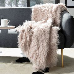 a living room with a couch, coffee table and pictures on the window sill