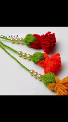 three tassels with pearls and beads are shown in red, orange and green