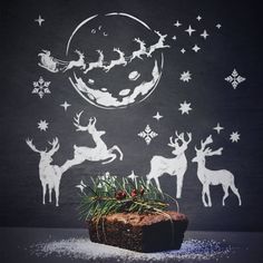 a cake sitting on top of a table covered in frosting and reindeer silhouettes