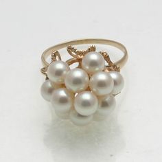 "This is a beautiful estate pearl ring. This stunning ring is made of 14k yellow gold. It is a vintage cocktail ring with 12 pinkish white pearls in the center. The gallery has elegantt detailing. The ring is in excellent condition for its age! It looks like it was hardly worn and is stamped \"K14.\" The ring is currently a size 9, please contact me for sizing information. The ring measures approximately 18mm in diameter. It comes in a beautiful pouch perfect for safekeeping or gift giving!" Formal White 14k Gold Pearl Ring, White 14k Oval Pearl Ring, Elegant Formal Cluster Pearl Ring, Elegant Cluster Pearl Ring For Formal Occasions, Fine Jewelry White Pearl Ring Stamped 14k, White Pearl Ring Stamped 14k, Elegant White Pear-shaped Ring, Elegant Cluster Pearl Ring Gift, Elegant Cluster Pearl Ring As A Gift