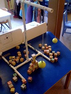 a blue table topped with lots of blocks and balls next to a sewing machine on top of it