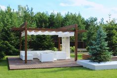 a white couch sitting on top of a wooden deck next to a lush green forest