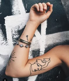 a woman's arm with a tattoo on it that has an image of a dog