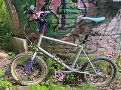 a bike parked next to a graffiti covered wall