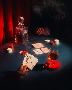 a person sitting at a table with cards and candles on it in front of them