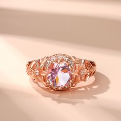 This exquisite piece showcases a captivating combination of elegance and femininity. Crafted in sterling silver, this beautiful ring showcases a sparkling round-cut morganite stone radiating a soft and romantic glow and flower detailing along the ring's shank lending heirloom appeal to this elegant design. Delicate and romantic, this ring is the perfect choice for her.Carat Weight: 1.28 ctStone Size: 7 mmStone Type: Jeulia® StoneNumber of Stones: 1 Stone Shape: RoundStone Color: Fancy PinkCarat Weight: 0.394 ctStone Size: 1,1.3,1.4,1.6,1.8 mmStone Type: Jeulia® StoneNumber of Stones: 16 Stone Shape: RoundStone Color: Diamond WhiteWeight: 4.5 gWidth: 1.1 mmHeight: 7.4 mmThickness: 2.8 mmMaterial: 925 SilverPlating Color: Rose Gold Elegant Morganite Diamond Ring With Gemstone, Elegant Morganite Diamond Ring With Prong Setting, Elegant Morganite Diamond Ring With Round Cut, Elegant Morganite Ring With Center Stone, Elegant Morganite Wedding Ring With Brilliant Cut, Elegant Morganite Wedding Jewelry With Center Stone, Elegant Pink Cluster Ring With Brilliant Cut, Elegant Morganite Ring For Formal Occasions, Elegant Morganite Rings For Formal Events