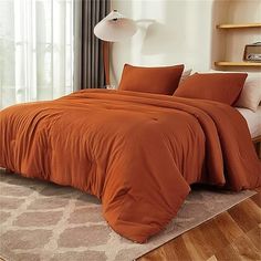 an orange comforter on a bed in a bedroom