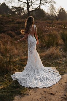 the back of a woman's dress as she walks through an open field