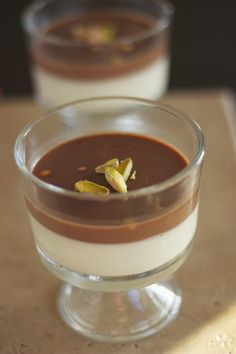 two desserts in small glass bowls on a table with one chocolate pudding and the other white