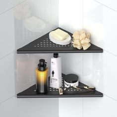 two black shelves with different items on them in a white tiled bathroom, one shelf has soap, the other is lotion and toiletries