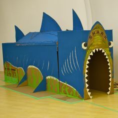 there is a cardboard box with a shark's mouth in the shape of a house