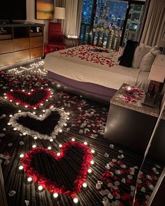 a bedroom decorated for valentine's day with candles in the shape of a heart