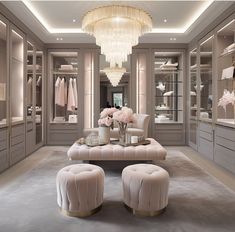 an elegant walk - in closet with chandelier and foot stools