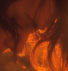 a close up of a woman's face with her hair blowing in the wind