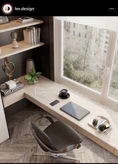 a computer desk with headphones and a laptop on it next to a large window