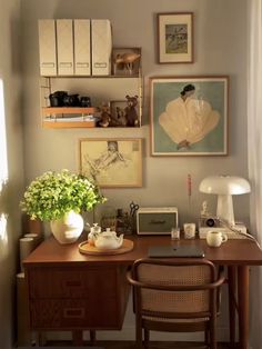 a room with a desk, chair and pictures on the wall above it is shown