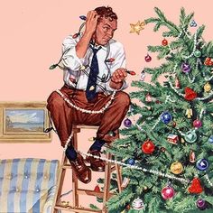 a man sitting on a stool next to a christmas tree