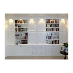 a living room filled with lots of white bookshelves