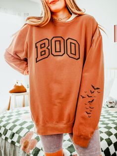 Get into the spooky season spirit with our Boo Sweatshirt, a cozy Halloween crewneck featuring varsity letter designs and a playful bat sleeve print. ABOUT THE SWEATSHIRT Comfort Colors 1466 100% ring-spun cotton Light fabric  OEKO-TEX certified low-impact dyes Relaxed Fit  Size up 1-2 sizes for oversized fit SHIPPING AND PROCESSING All sweatshirts are processed and shipped within 1-7 business days from purchase.  RETURN POLICY We want you to be happy with your purchase! if you need to request a Oversized Halloween Hoodie With Letter Print, Oversized Hoodie With Letter Print For Halloween, Fan Apparel Long Sleeve Sweatshirt For Fall, Fan Apparel Sweatshirt With Ribbed Cuffs For Fall, Fall Fan Apparel Hoodie With Graphic Print, Fall Fan Apparel Hoodie With Letter Print, Varsity Hoodie Sweatshirt For Fall, Oversized Fan Apparel Sweatshirt For Fall, Orange Letter Print Crew Neck Hoodie