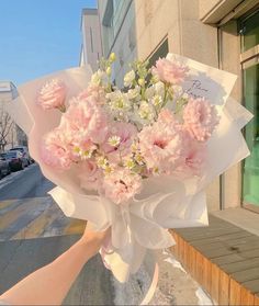 a person holding a bouquet of flowers on the street