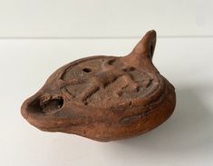 a clay animal head on a white surface