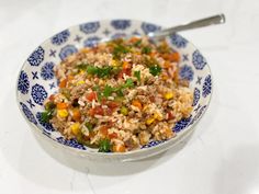 a bowl filled with rice and vegetables on top of a table